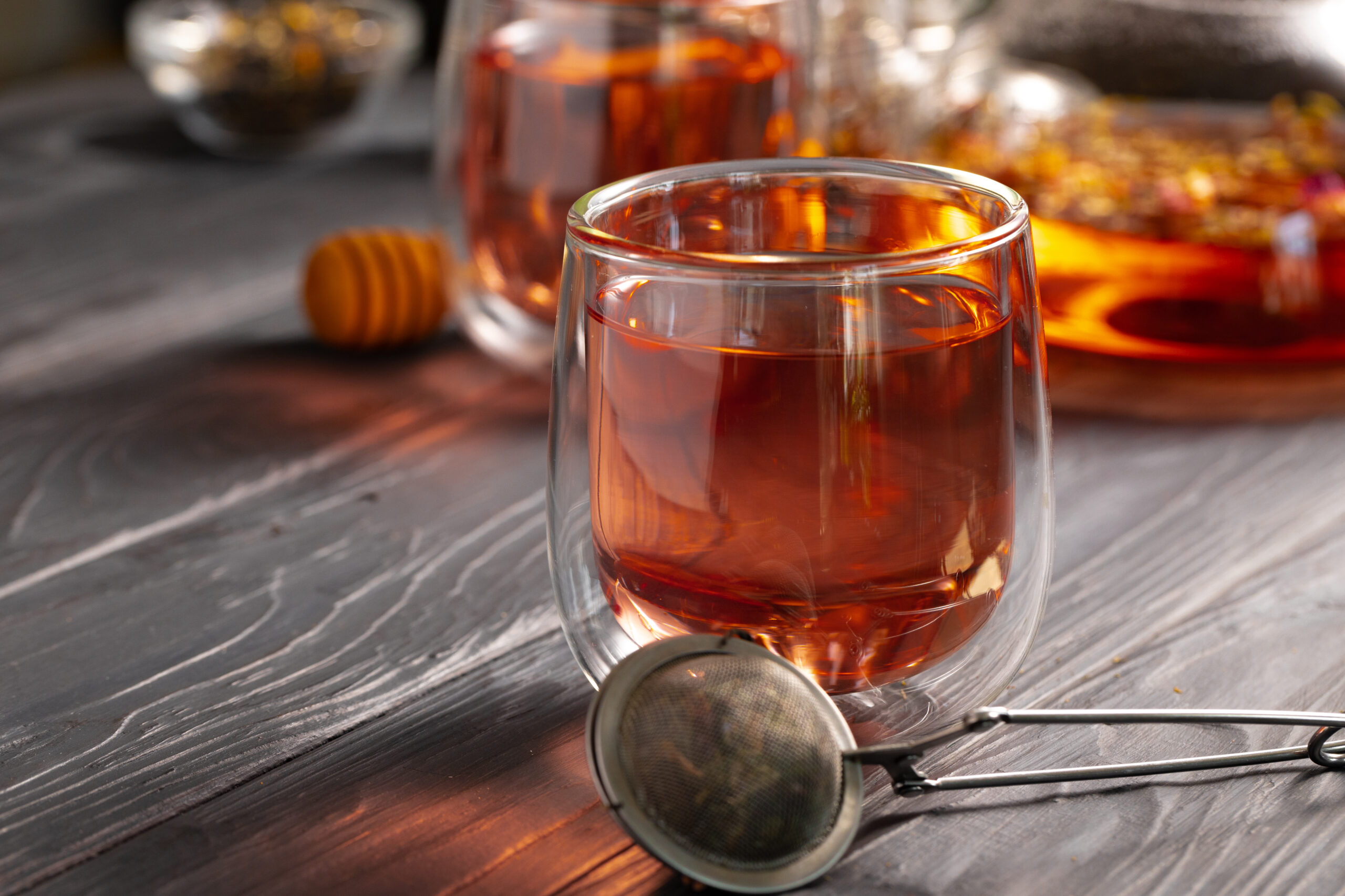 Glass tea cup and teapot on table